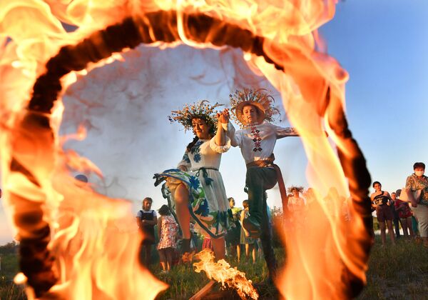 Девушка и юноша прыгают через огонь на празднике Ивана Купалы на берегу залива Припяти в древнем белорусском Турове - Sputnik Южная Осетия