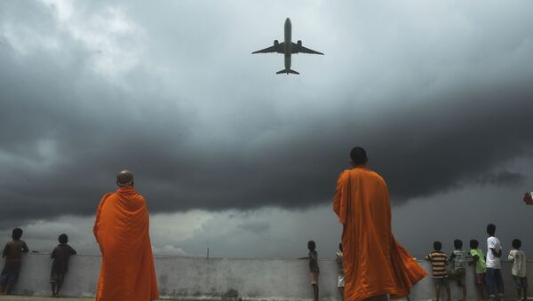Буддийские монахи и дети наблюдают за взлетом самолета из международного аэропорта имени Нетаджи Субхас Чандра Боса в Калькутте - Sputnik Южная Осетия