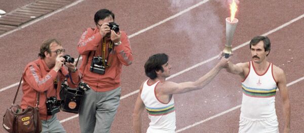 Олимпийский чемпион Сергей Белов (справа) принимает факел с олимпийским огнем из рук трехкратного олимпийского чемпиона Виктора Санеева (слева). - Sputnik Южная Осетия