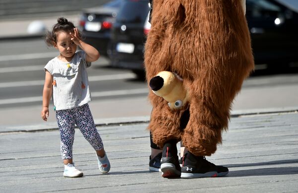 Девочка смотрит на уличного артиста в костюме медведя из мультфильма Маша и медведь в Киеве, Украина - Sputnik Южная Осетия