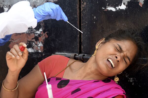Медработник берет мазок у женщины для теста на коронавирус в жилом районе Ченнаи, Индия - Sputnik Южная Осетия