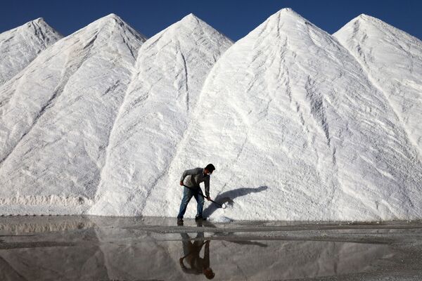 Рабочий соляного завода Коюнджу сгребает большие груды соли на турецком озере Туз в Анкаре. - Sputnik Южная Осетия