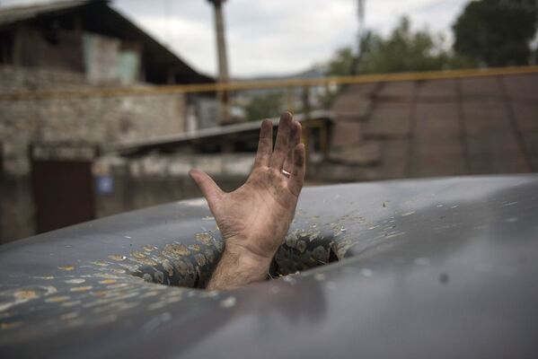 Пробоина в крыше автомобиля, появившаяся в результате обстрелов Степанакерта в Нагорном Карабахе - Sputnik Южная Осетия