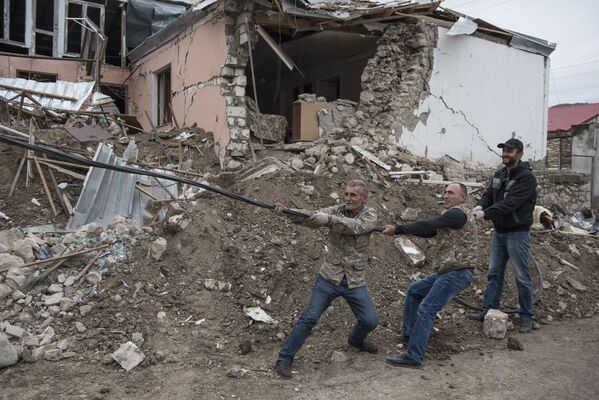 Мужчины во время восстановления электрических сетей, поврежденных в результате обстрелов Степанакерта в Нагорном Карабахе. - Sputnik Южная Осетия