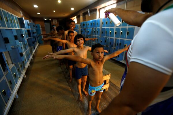 Дезинфекция детей перед занятием в бассейне в городе Кербела, Ирак  - Sputnik Южная Осетия