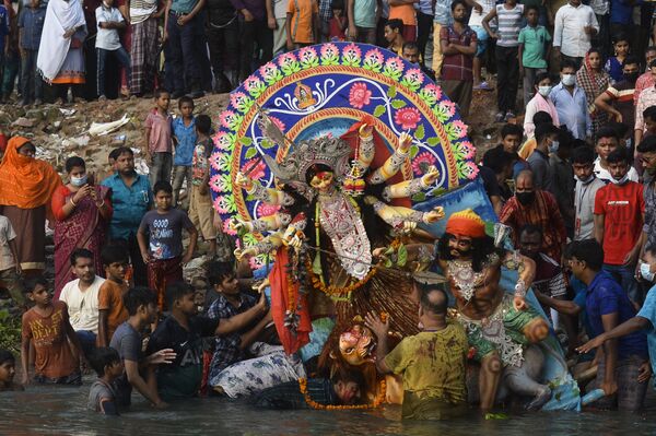 Индуисты около глиняного идола богини Дурга в завершающий день фестиваля Дурга-пуджа в Дакке, Бангладеш - Sputnik Южная Осетия