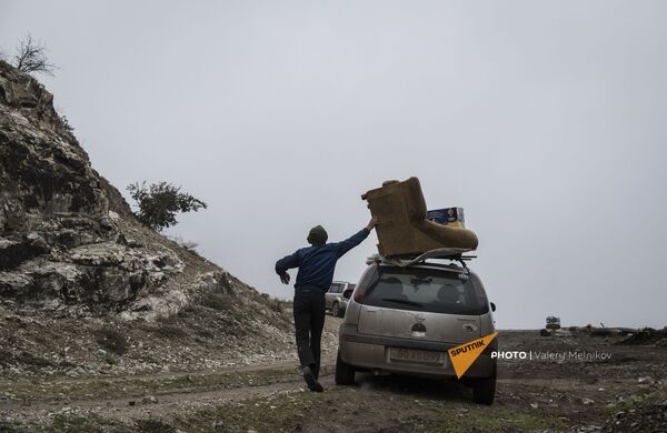 Мужчина с перегруженным вещами автомобилем покидает свой дом в городе Бердзор (30 ноября 2020). Карабах - Sputnik Южная Осетия