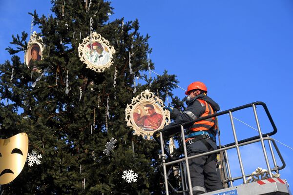 Рабочий вешает портрет Сергея Дягилева на ёлку, установленную возле Северного речного вокзала в Москве - Sputnik Южная Осетия