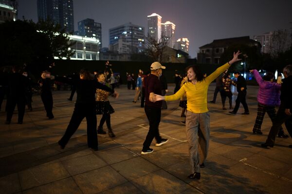 Люди танцуют ночью парке спустя год после вспышки COVID-19 в Ухане - Sputnik Южная Осетия