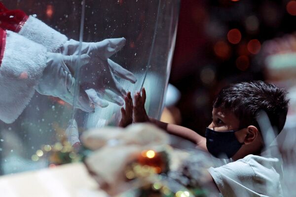 Ребенок общается с Санта Клаусом через пластиковый экран в шоппинг-центре в Бразилии - Sputnik Южная Осетия