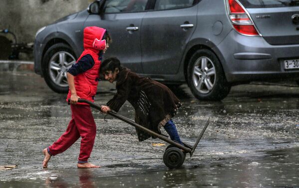 Палестинские дети в дождливый день в Рафахе на юге сектора Газа - Sputnik Южная Осетия