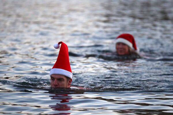 Люди в рождественских колпаках плаваю в озере Серпентин в Гайд-парке в Лондоне - Sputnik Южная Осетия
