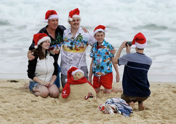 Семья в рождественских колпаках фотографируется на пляже в Сиднее, Австралия  - Sputnik Южная Осетия