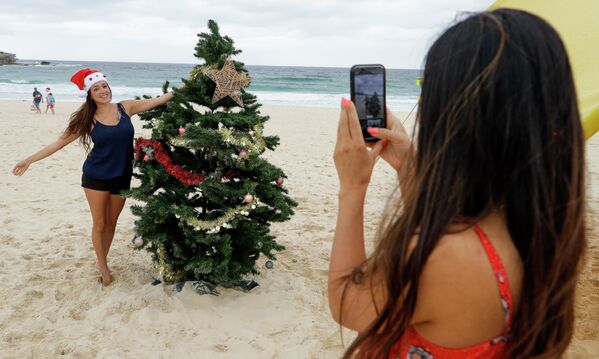 Девушки фотографируются у рождественской ели на пляже в Сиднее, Австралия  - Sputnik Южная Осетия