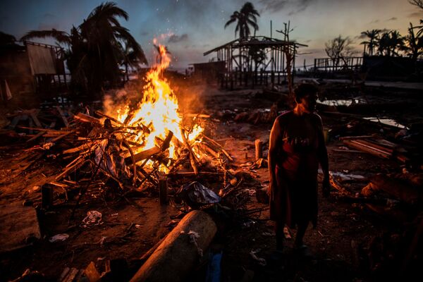 Люди сжигают мусор, оставшийся после урагана Йота в Бильви, Никарагуа - Sputnik Южная Осетия