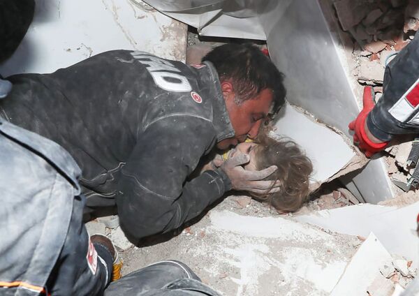 Турецкие спасатели вытаскивают ребенка из под обломков после землетрясения в Измире - Sputnik Южная Осетия