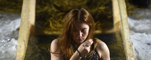 Девушка во время крещенского купания в проруби на реке Обь в черте Новосибирска. Девушка во время крещенского купания в проруби на реке Обь в черте Новосибирска. - Sputnik Южная Осетия