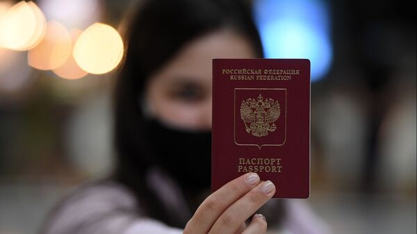 Девушка демонстрирует российский паспорт на стойке регистрации в международном аэропорту Казань. Архивное фото  - Sputnik Хуссар Ирыстон