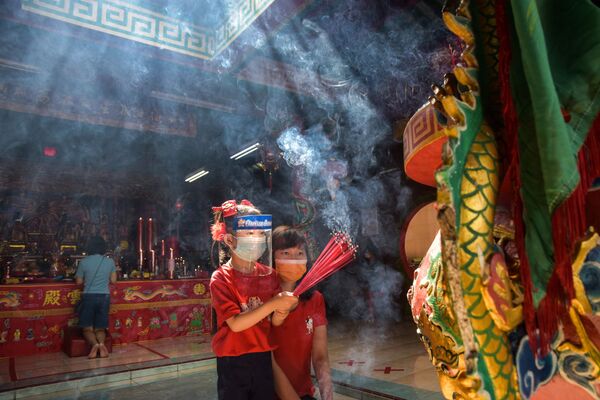 Девочки в защитных масках с ароматическими палочками во время празднования Нового года по лунному календарю в одном из храмов Индонезии - Sputnik Южная Осетия