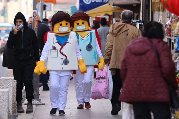 Люди в костюмах фигурок Lego идут по улице в канун праздника Пурим в Иерусалиме. - Sputnik Южная Осетия