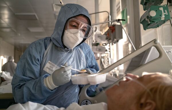 Медсестра кормит пациента в отделении реанимации и интенсивной терапии в больнице в Москве - Sputnik Южная Осетия