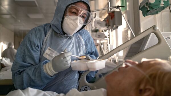Медсестра кормит пациента в отделении реанимации и интенсивной терапии в больнице в Москве - Sputnik Южная Осетия