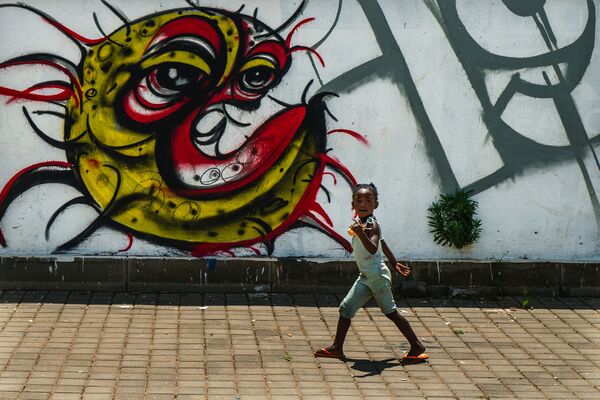 Ребенок у граффити с изображением COVID-19 в Совето, ЮАР - Sputnik Южная Осетия