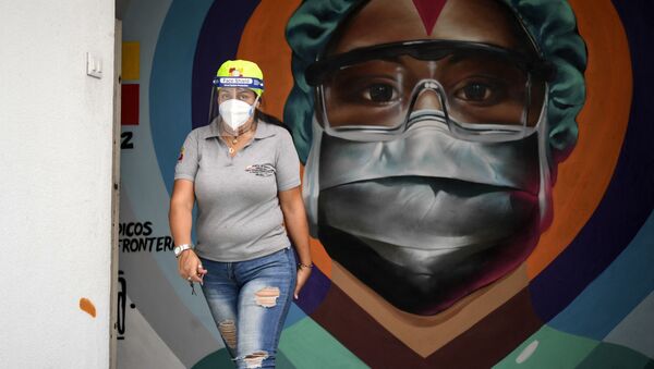 Медицинский работник в защитной маске у граффити в Каракасе - Sputnik Южная Осетия