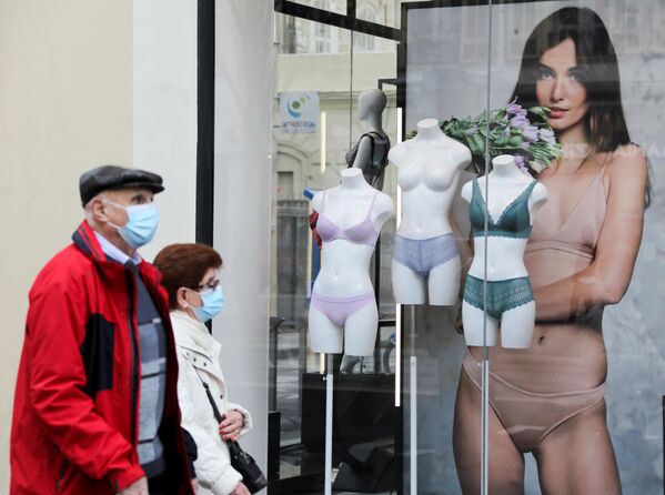 Люди в защитных масках проходят мимо магазина нижнего белья во время карантина в Ницце, Франция - Sputnik Южная Осетия