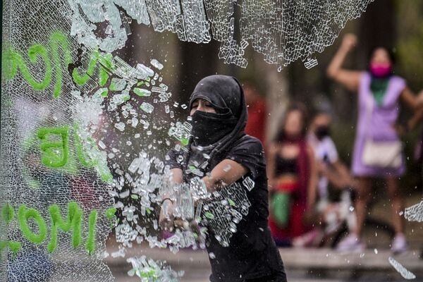 Женщина разбивает стекло в ходе посвященной Международному женскому дню демонстрации в Мехико, Мексика - Sputnik Южная Осетия