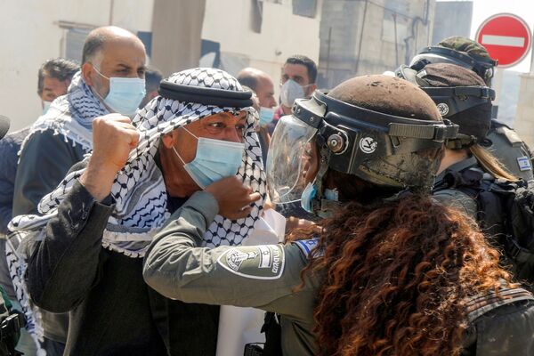 Палестинский демонстрант дерется с израильской пограничницей во время акции протеста в честь Дня земли в Себастии на оккупированном Израилем Западном берегу - Sputnik Южная Осетия