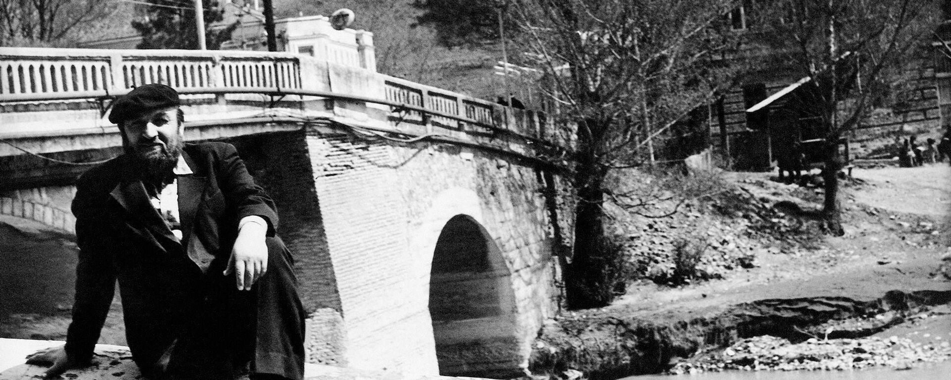 Художник Хсар Гассиев на фоне старого моста - Sputnik Южная Осетия, 1920, 13.04.2021