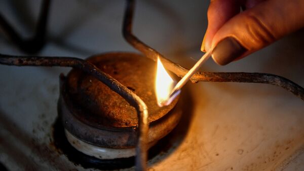 Женщина зажигает конфорку газовой плиты - Sputnik Южная Осетия