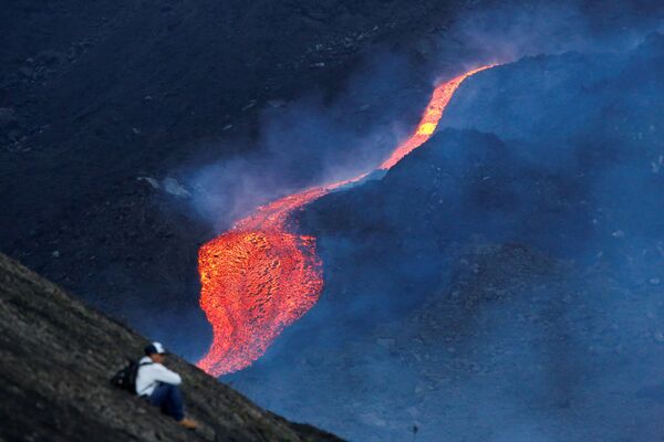 Мужчина наблюдает за течением раскаленной лавы вулкана Пакая в регионе Эскуинтла, Гватемала - Sputnik Южная Осетия