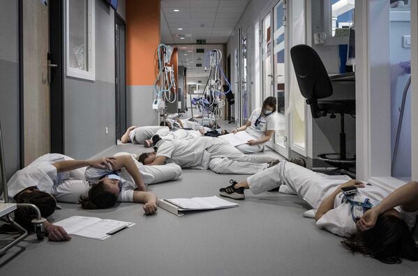 Медсестры и медперсонал лежат на полу в отделении интенсивной терапии во время демонстрации в Международный день медсестер и ухода в больнице Mont Legia в Льеже, Бельгия - Sputnik Южная Осетия