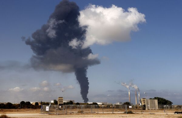Шлейф дыма от бушующего пожара на нефтехимическом складе вздымается на нефтехранилище, пораженном ракетами ХАМАС в городе Ашкелон - Sputnik Южная Осетия