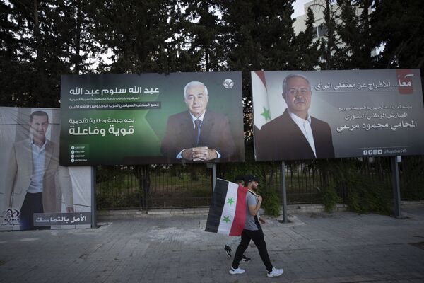 Мужчина с сирийским флагом у агитационных билбордах в Дамаске - Sputnik Южная Осетия