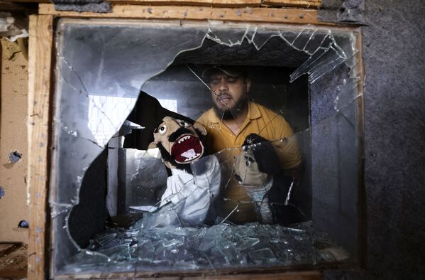 Палестинский комик Мохаммед Саед показывает марионеток, которые он спас в городе Газа - Sputnik Южная Осетия