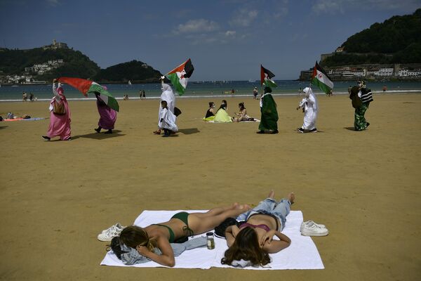 Демонстранты из Сахары размахивают флагами, принимая участие в митинге на пляже в Сан-Себастьяне, Испания - Sputnik Южная Осетия