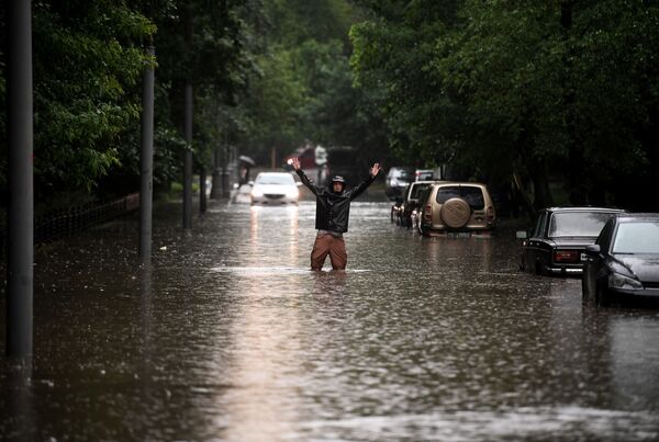 Мужчина на одной из улиц в Москве во время дождя - Sputnik Южная Осетия