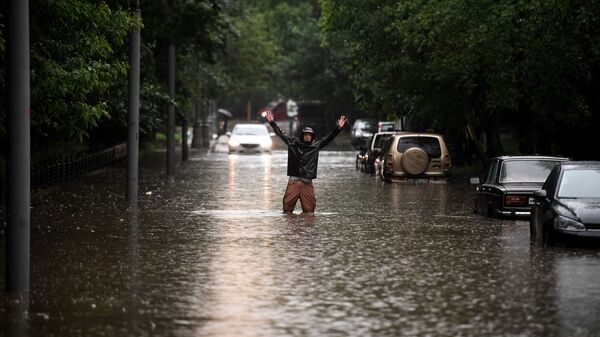 Мужчина одной из улиц в Москве во время дождя - Sputnik Южная Осетия