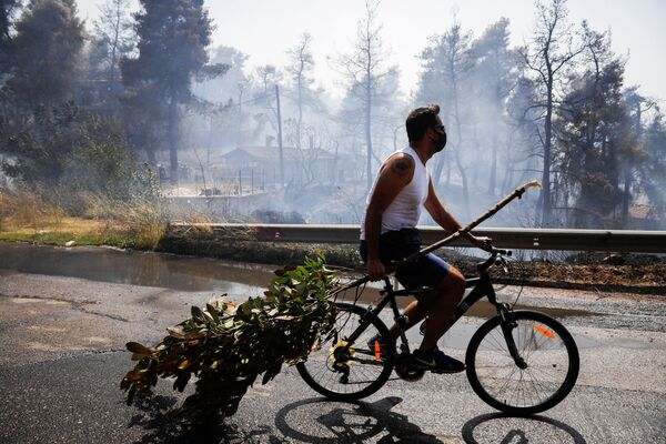 Мужчина на велосипеде во время природных пожаров в Греции  - Sputnik Южная Осетия