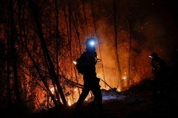 Пожарный тушит огонь у греческого города Патры - Sputnik Южная Осетия