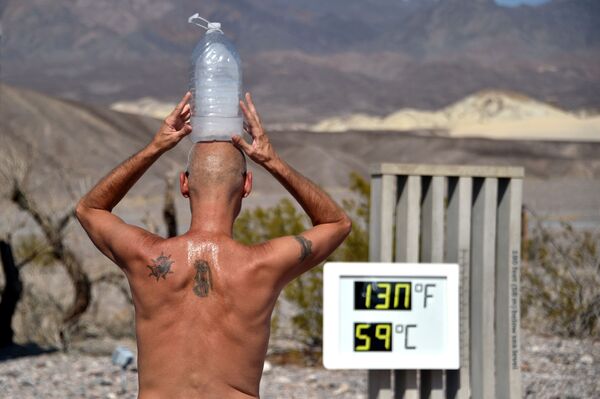 Мужчина с бутылкой льда на голове во время высокой температуры в Долине Смерти, Калифорния  - Sputnik Южная Осетия