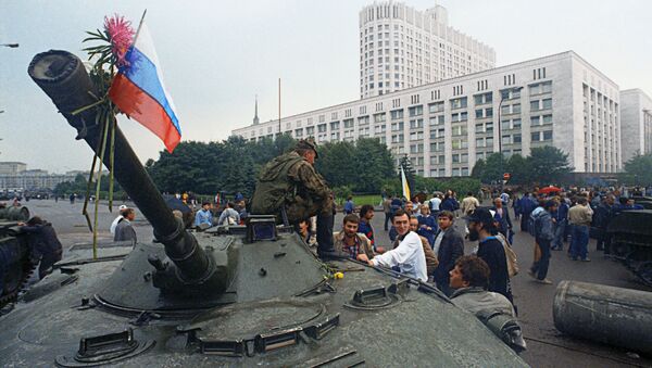 Защитники Белого дома прикрепили цветы к орудийному стволу одного из танков, введеных в Москву 19 августа 1991 года в связи с объявлением членами ГКЧП чрезвычайного положения в столице. - Sputnik Южная Осетия