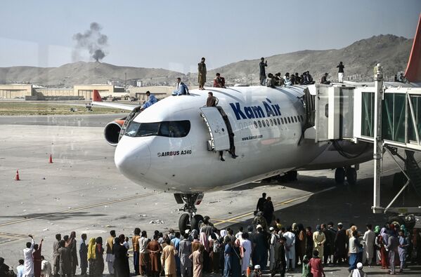 Афганцы забираются на самолет в аэропорту после вступления талибов в Кабул - Sputnik Южная Осетия