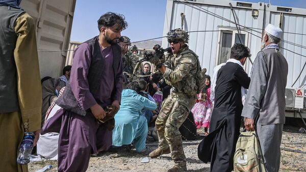 Американский солдат целится на афганцев в аэропорту Кабула  - Sputnik Южная Осетия