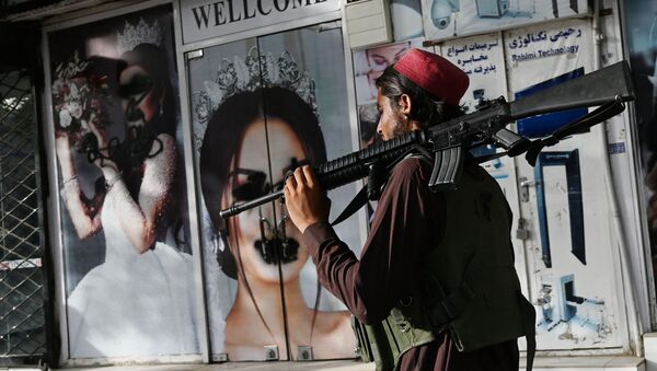 Боевик Талибана* у салона красоты с изображениями женщин, испачканных аэрозольной краской, в Шахр-э Нау в Кабуле - Sputnik Южная Осетия