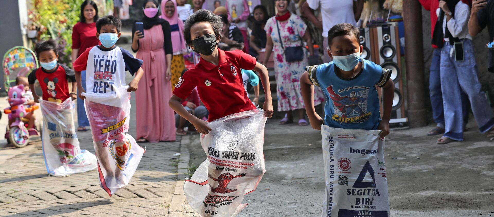 Дети в масках принимают участие в соревнованиях по бегу на мешках во время празднования Дня независимости в Джакарте, Индонезия - Sputnik Южная Осетия, 1920, 04.09.2021