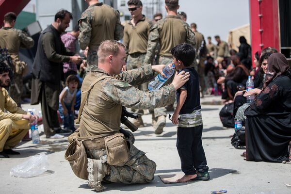 Американский солдат дает воду ребенку в аэропорту Кабула  - Sputnik Южная Осетия